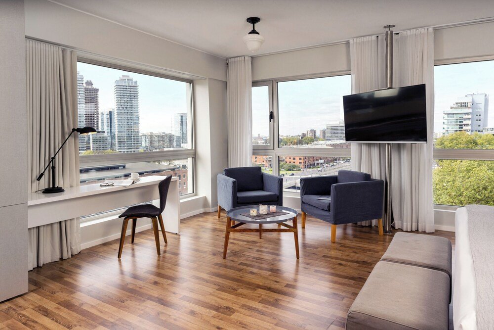 Salon aux grandes fenêtres dans une suite d'hôtel