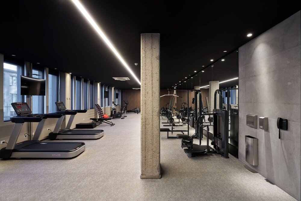 Moderner 24-Stunden-Fitnessraum mit Laufbändern und Kraftgeräten