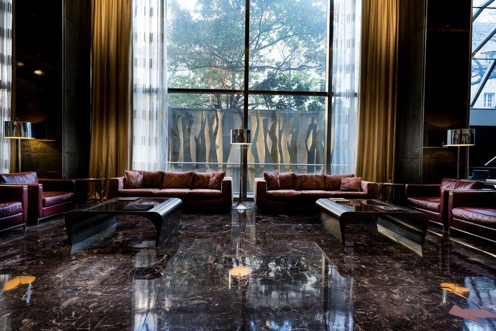 Hotellobby mit Ledersofas und Glaswand