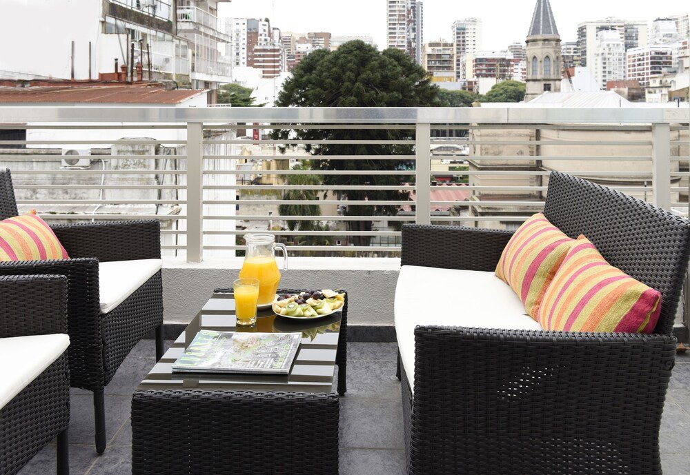 Terraço na cobertura com móveis de vime no hotel de suítes
