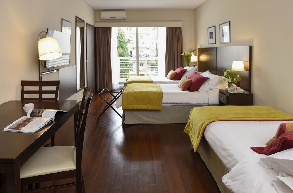 Quarto de hotel com duas camas e escrivaninha