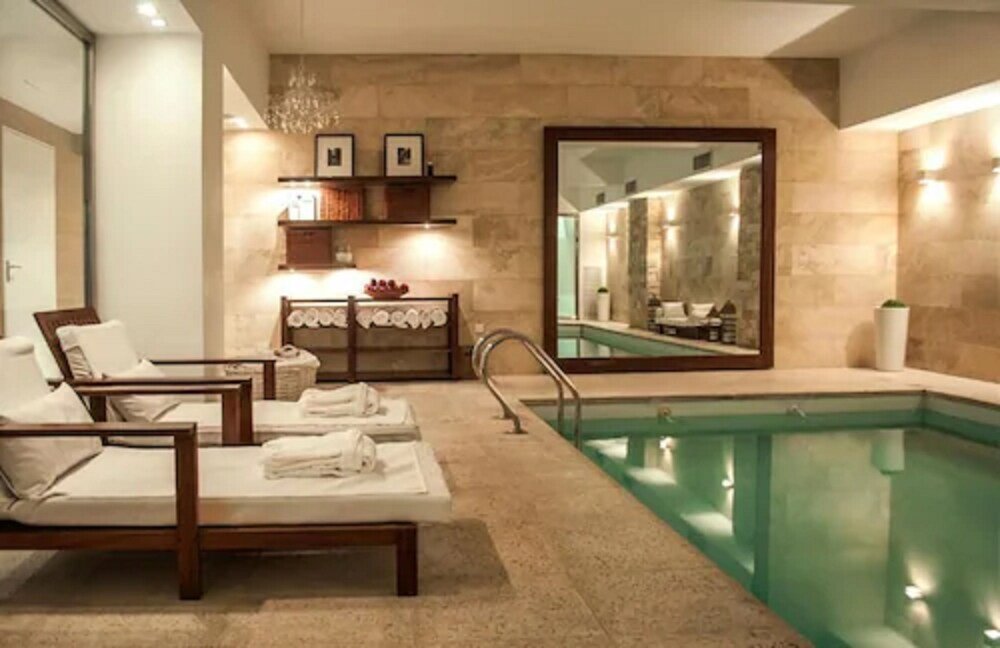 Spa area with a pool and lounge chairs at Awwa Suites