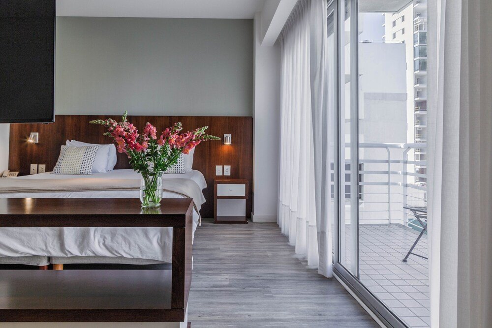 Hotel room with a bed and a bedside table at Color Botánico