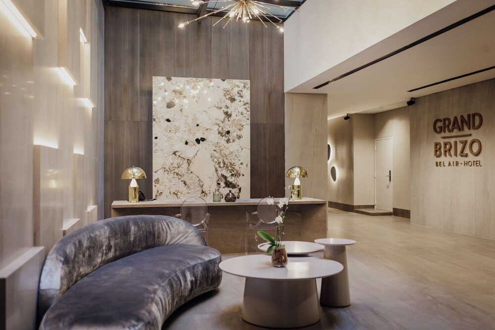Lobby moderno de hotel com sofá curvo no Grand Brizo Bel Air