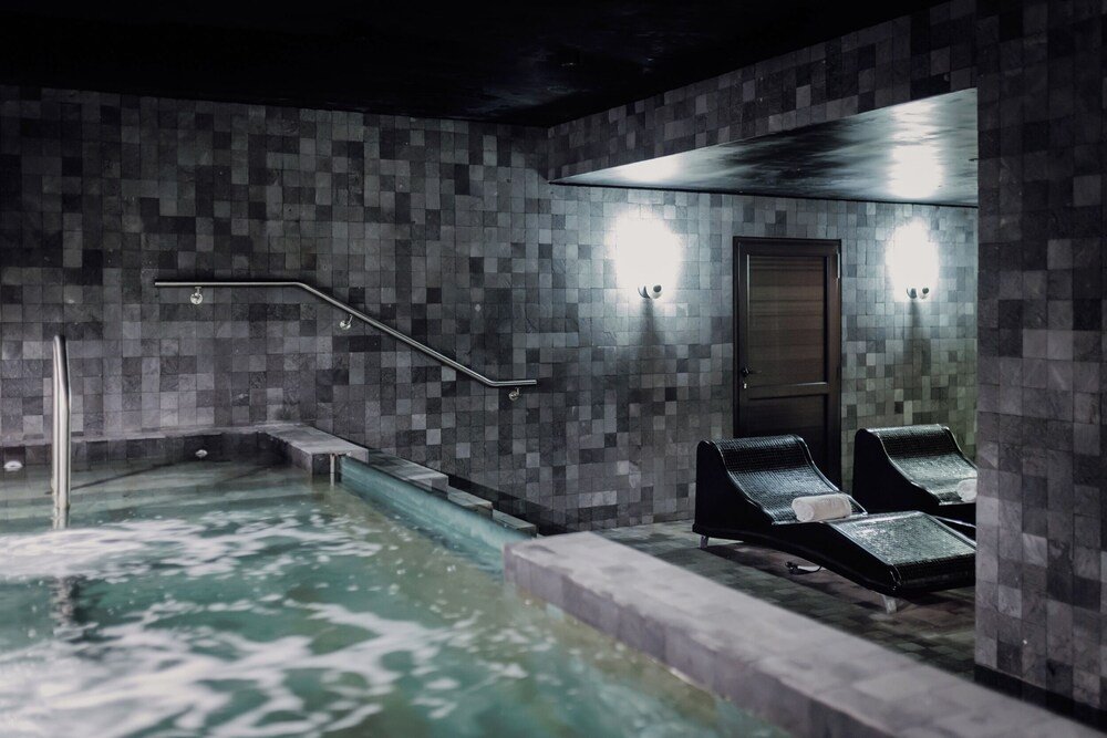 Área do spa com parede revestida de azulejos e banheira de hidromassagem