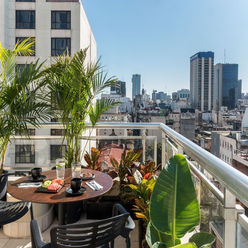 Rooftop terrace with a set table at HTL City Baires
