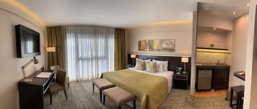 Quarto de hotel com cama, escrivaninha e cadeira no Konke