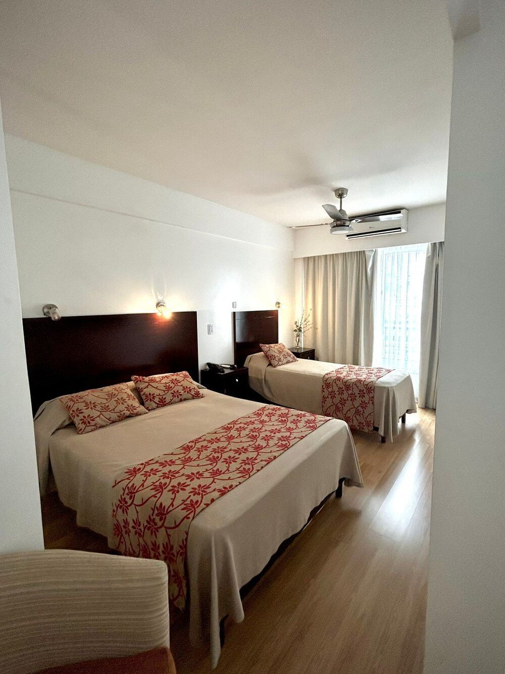 Hotelzimmer mit zwei Betten und schlichter, moderner Einrichtung