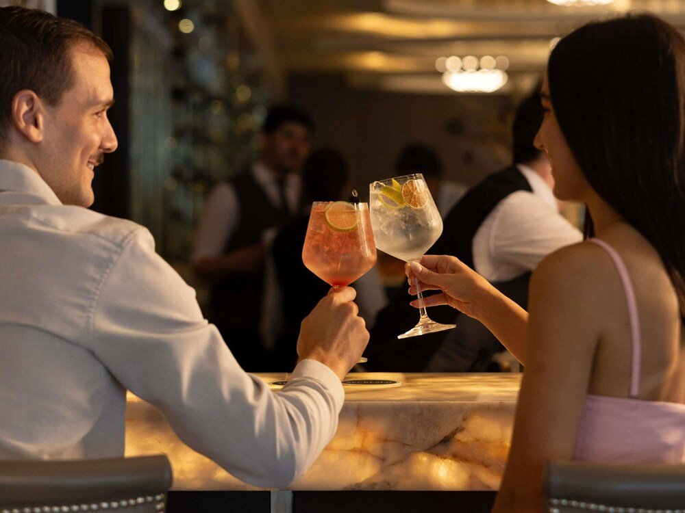 Casal brindando com bebidas em um bar